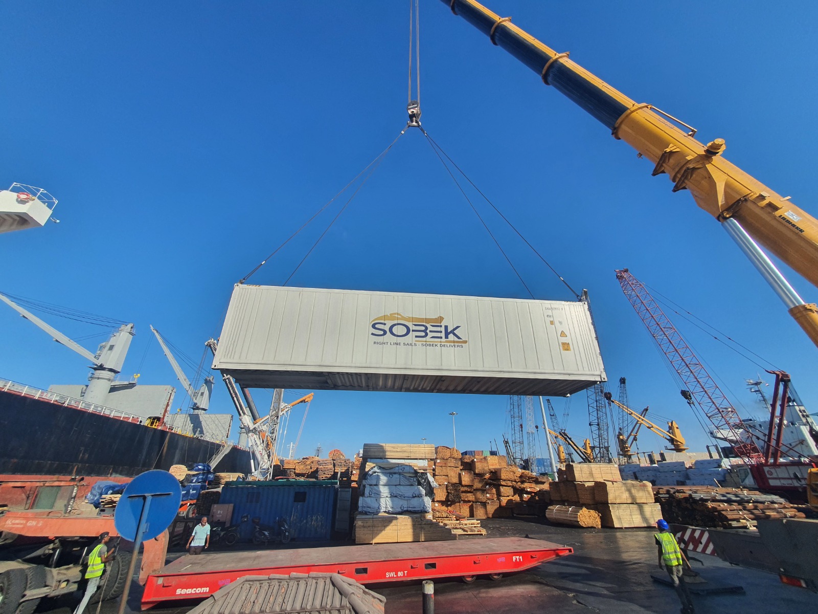 Sobek container suspended above a lumber yard