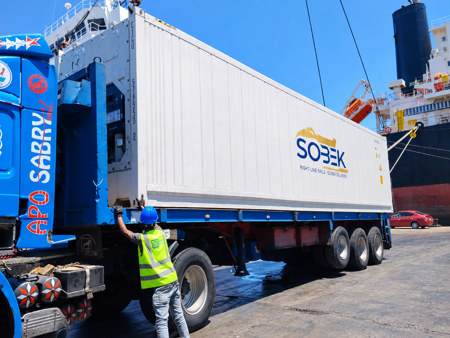 Stevedore guiding a Sobek container onto a truck